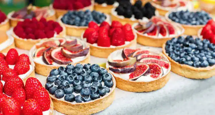 Fresh berry tarts with blueberries, raspberries, and strawberries for bakery and market sales.